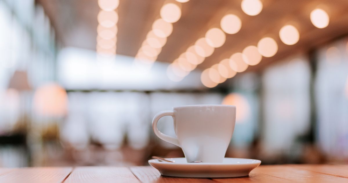 Small coffee cup or demitasse cup on the counter of a shop with lights